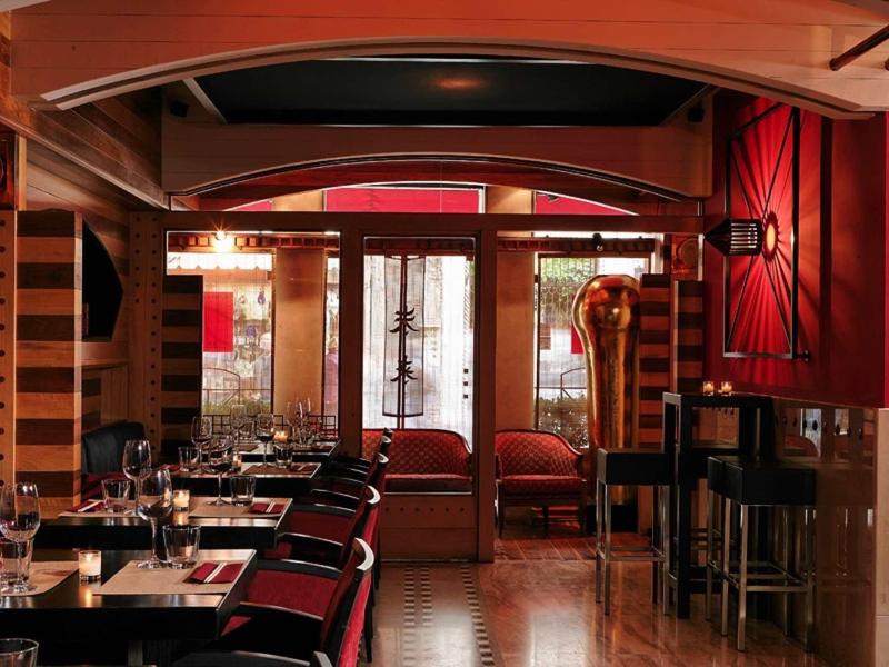 Cozy hotel bar with red walls, chairs, and warm wood decor