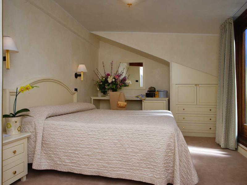 Bright, simply furnished hotel room with double bed and large window