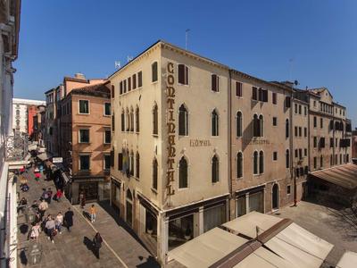 Street scene with historic building and cafés under clear sky