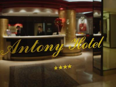 Elegante Hotellobby mit rundem Empfangstresen, warmer Beleuchtung und vier Sternen darunter.