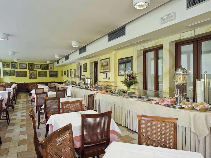 Large dining room with set tables and buffet along one wall.