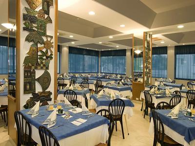 Restaurant with blue-covered tables and chairs in a modern interior space.