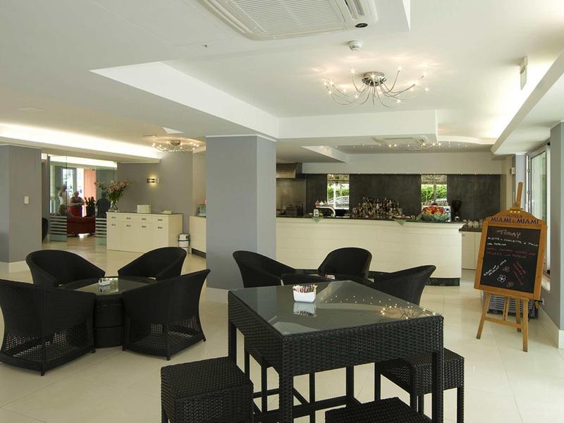 Modern hotel lounge area with black seating and white interior.