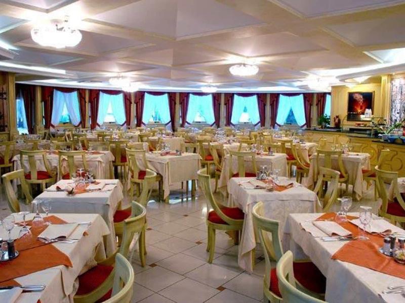 Elegant restaurant with set tables, red chairs, and large windows.