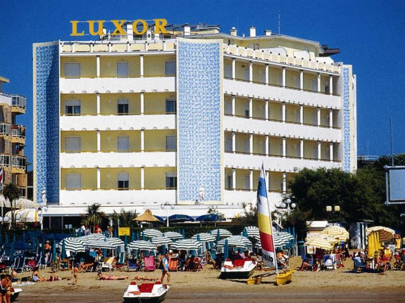 Multi-story Luxor hotel with blue tiles and beach umbrellas