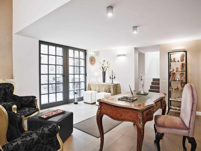 Elegancki salon z antycznymi meblami, dużymi oknami i ciepłym oświetleniem.