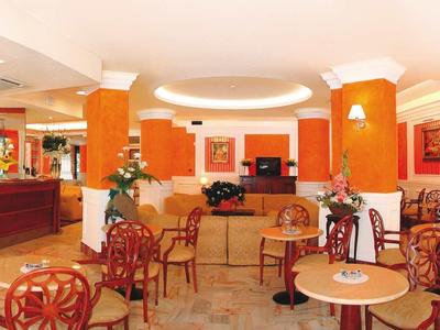 Helles Café mit Holzstühlen, Tischen und einer Bar im Hintergrund.