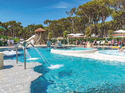 Freizeitpool im Freien mit Wasserfällen und Sonnenschirmen in einem Hotelresort.