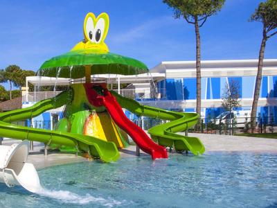 Wasserpark mit großer grün-gelber Wasserrutsche in Form eines Froschs und blauem Schwimmbecken.