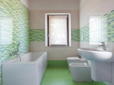 Modernes Badezimmer mit grünen Fliesen, Badewanne, Waschbecken, Bidet und Toilette.