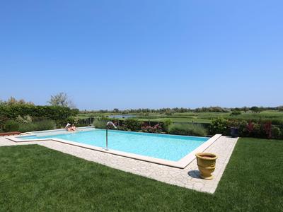 Moderne Küche mit weißen und dunklen Schränken, Esstisch mit vier Stühlen, hellem Fliesenboden.