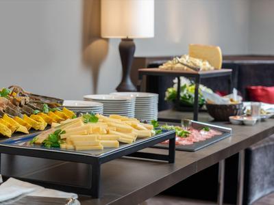 Buffet mit Käse, Brot und Aufschnitt in einem gemütlichen Hotelzimmer