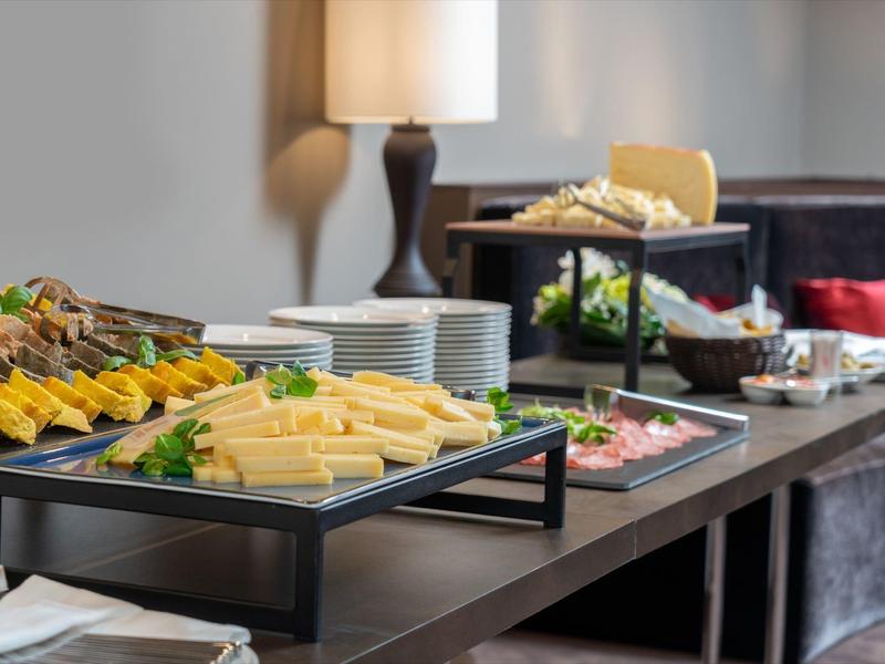 Buffet mit Käse, Brot und Aufschnitt in einem gemütlichen Hotelzimmer