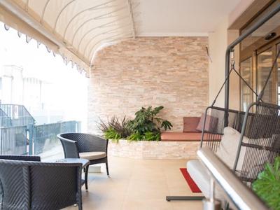 Terrazza accogliente con posti a sedere e piante per momenti di relax in hotel.