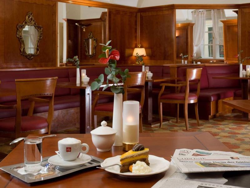 Gemütliches Café mit Holzmöbeln, gedecktem Tisch, Kuchen, Kaffee und Zeitung.