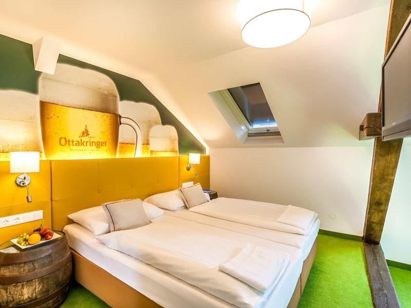 Gemütliches Schlafzimmer mit zwei Betten, grünem Teppich und Dachfenster unter schräger Decke.