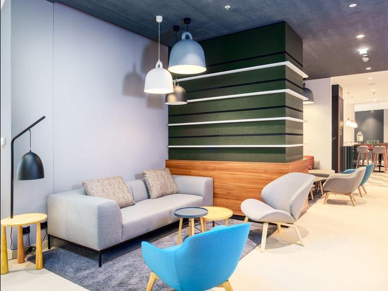 Modern eingerichteter Hotel-Loungebereich mit Sofas, Sesseln und dekorativen Lampen.