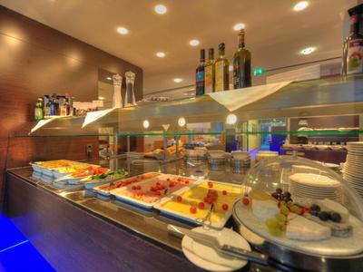 Buffet mit verschiedenen warmen und kalten Speisen in einer modernen, gut beleuchteten Umgebung.