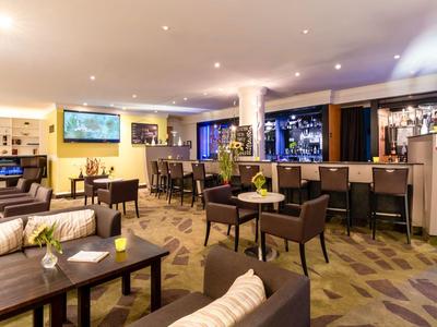 Bar dell'hotel moderna con aree salotto e atmosfera calda.