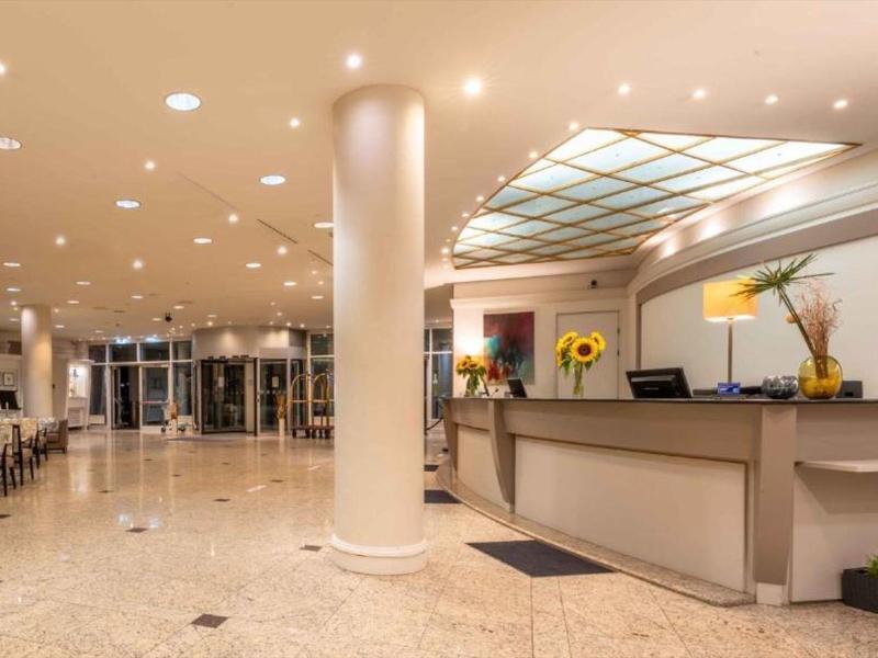 Lichte hotel lobby met receptiebalie, zuil en moderne verlichting