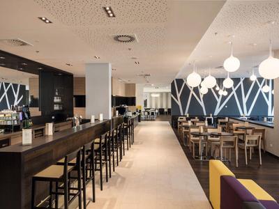 Area bar moderna dell'hotel con posti a sedere e illuminazione elegante.