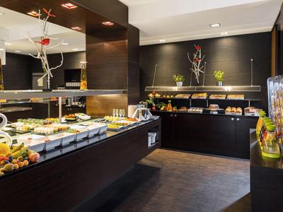 Nowoczesna jadalnia z różnorodnym bufetem i eleganckim oświetleniem.