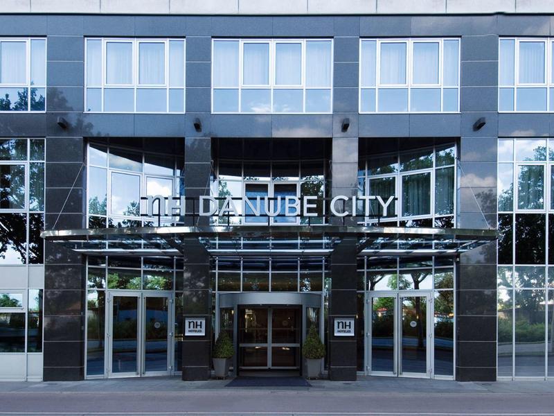 Nowoczesny hotel z czarną szklaną elewacją i dużymi drzwiami wejściowymi