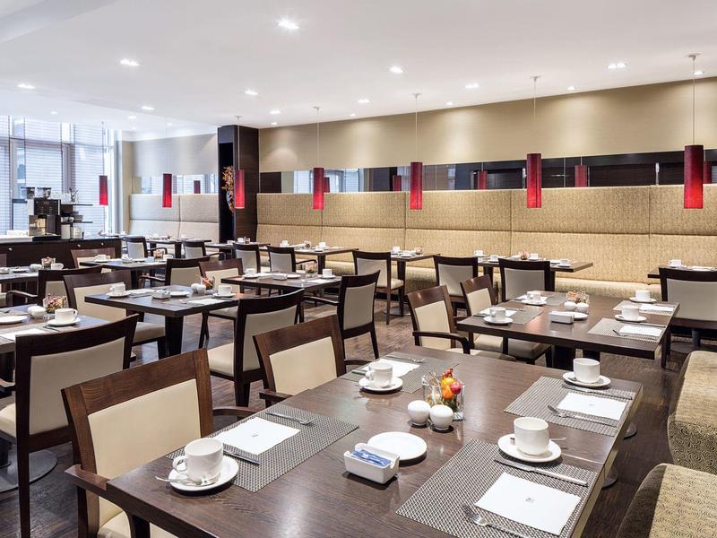 Nowoczesna restauracja z nakrytymi stołami i wygodnymi krzesłami w hotelu.