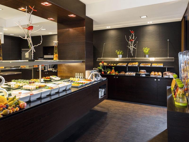 Nowoczesna jadalnia z różnorodnym bufetem i eleganckim oświetleniem.