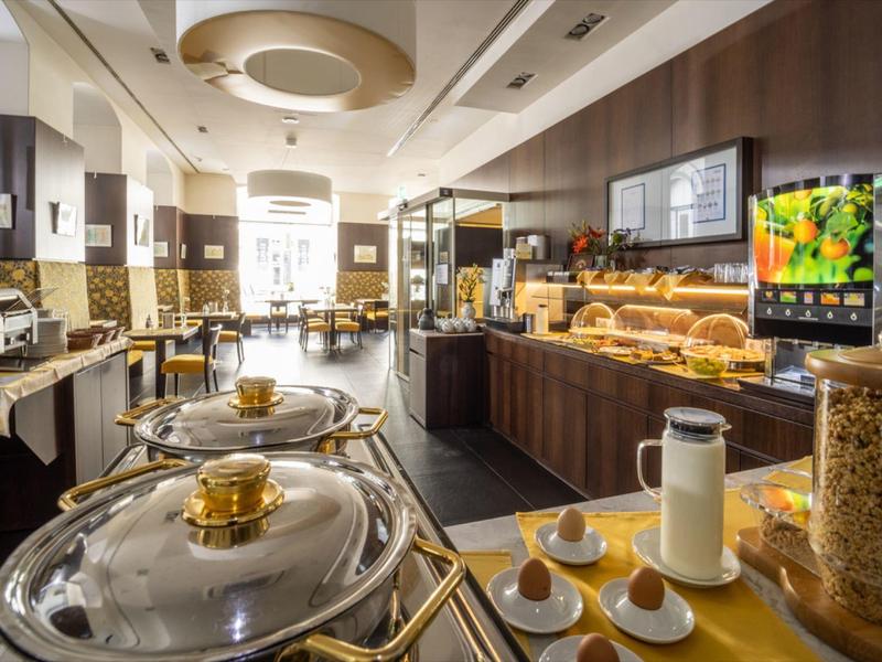 Strefa bufetu w hotelu z różnymi opcjami śniadaniowymi i gorącymi potrawami.