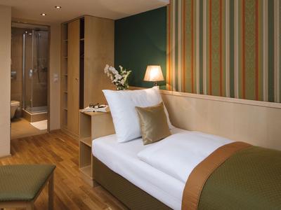 Přátelský jednolůžkový pokoj s moderním nábytkem a teplým osvětlením v hotelu.