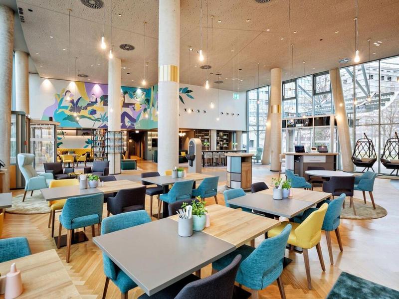 Bright, modern hotel lobby with seating area, colorful chairs, and large windows.