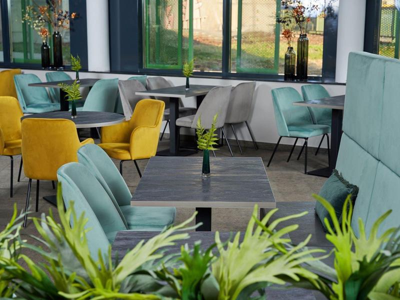 Modernly furnished hotel interior with colorful chairs and tables.