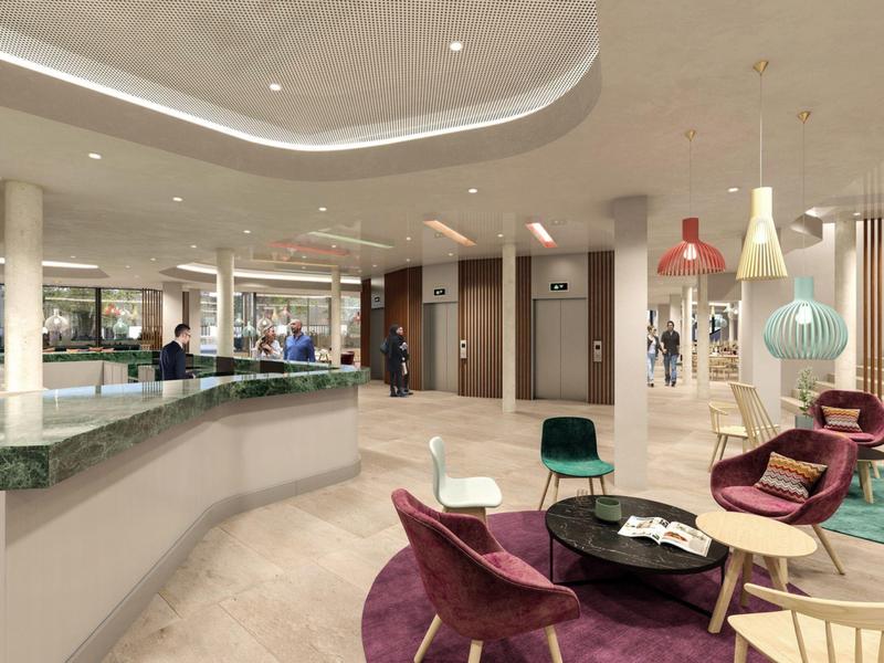 Area lounge moderna con poltrone colorate e lampade eleganti nella hall dell'hotel.