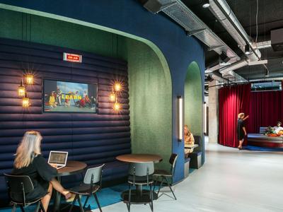 Modern lounge area with seating niches, tables, chairs, and a relaxed atmosphere.