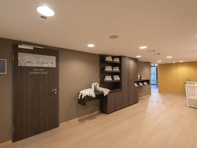 Corridoio arredato moderno con sedute e asciugamani impilati in un hotel.