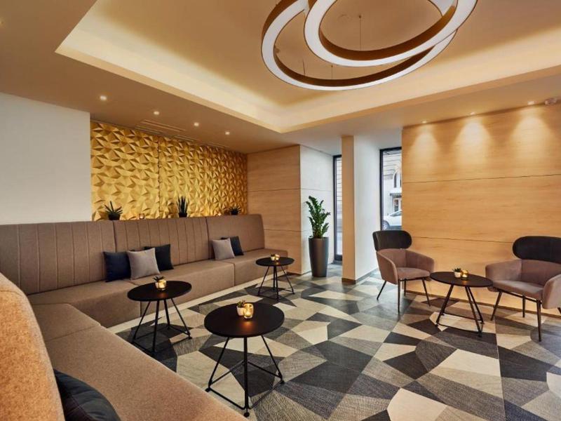 Modern hotel lounge area with seating and decorative lighting.