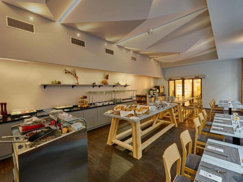 Modern buffet with seating in a hotel restaurant with warm lighting.