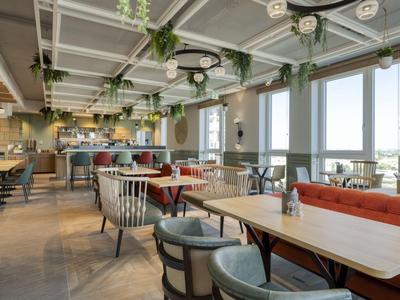 Modern dining area with large windows and colorful seating options.