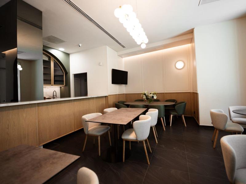 Modernes, schlichtes Restaurant mit Holzmöbeln und gedämpfter Beleuchtung.