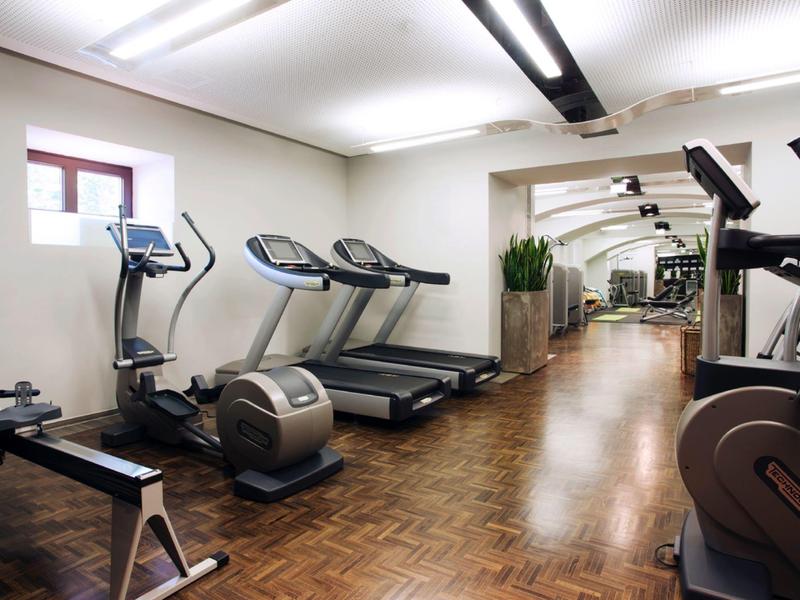 Moderner Fitnessraum mit Laufbändern und Trainingsgeräten auf Holzboden