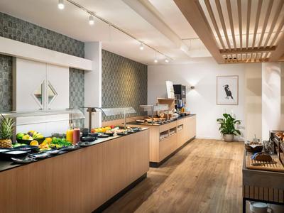 Salle de petit-déjeuner moderne avec buffet, meubles en bois et éclairage élégant.