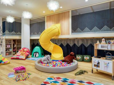 Bunter Kinderspielbereich mit Rutsche, Bällebad und Spielzeug in einem Hotelraum.