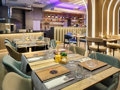 Restaurant moderne avec tables dressées et design élégant dans un hôtel.