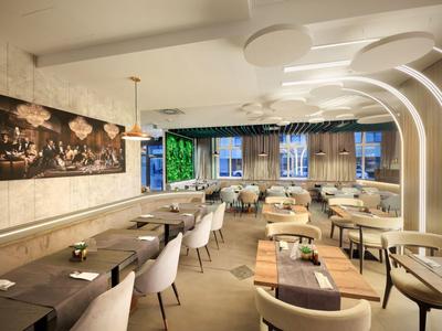 Salle à manger d'hôtel moderne et lumineuse avec sièges confortables et éclairage d'ambiance.