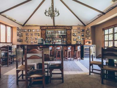 Helles, rustikales Hotelrestaurant mit Holzmöbeln, dekorativen Bildern und einer Bar.