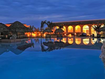 Abendliche Poolansicht mit beleuchteter Terrasse und ruhigem Wasser