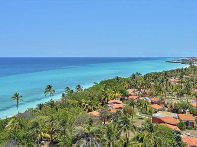 Blick auf eine Küste mit grüner Vegetation und blauer See unter klarem Himmel.
