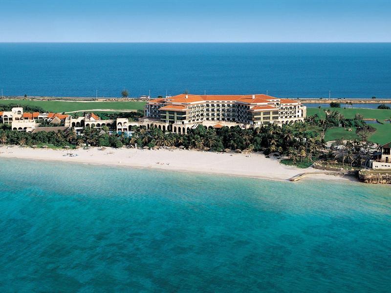Luxuriöses Strandresort mit klarem türkisfarbenem Wasser und weitläufigem Sandstrand.