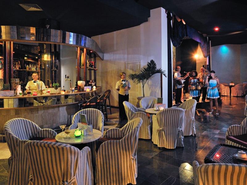 Gemütliches Café mit runden Tischen, bequemen Stühlen und gedämpfter Beleuchtung.